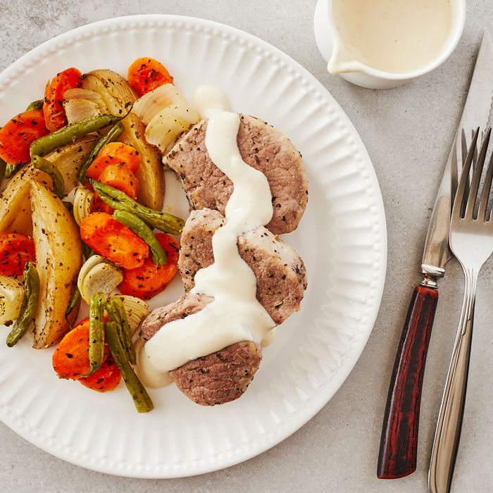 Filet de porc avec sauce à la moutarde servi avec légumes grillés et sauce crémeuse au yogourt grec.