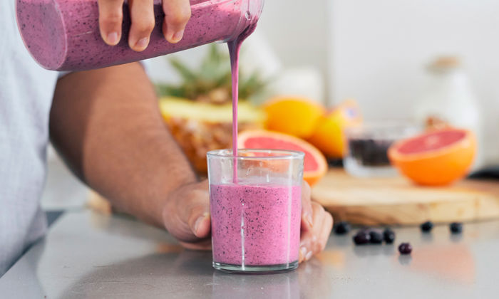Manque d’appétit : des mains d’homme versent un smoothie coloré dans un verre. 